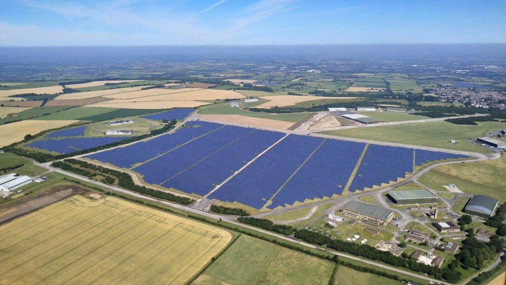 An aerial view of a large solar panel array in the English countryside.